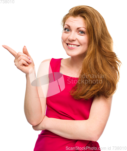 Image of Portrait of a young woman pointing to the left