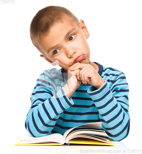 Image of Little boy is tired to read his book