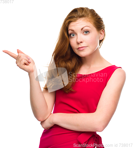 Image of Portrait of a young woman pointing to the left
