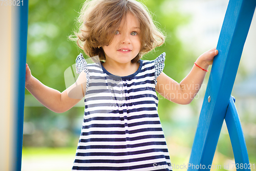 Image of Cute little girl is playing in playground