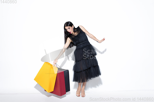 Image of Young woman in dress shopping on white background