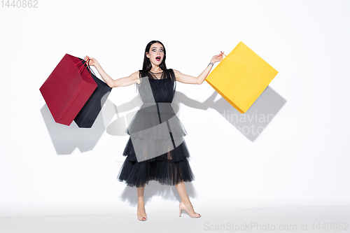 Image of Young woman in dress shopping on white background
