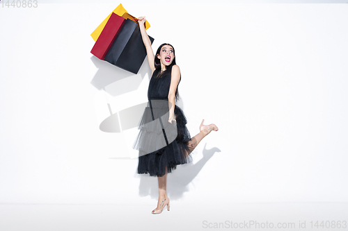 Image of Young woman in dress shopping on white background