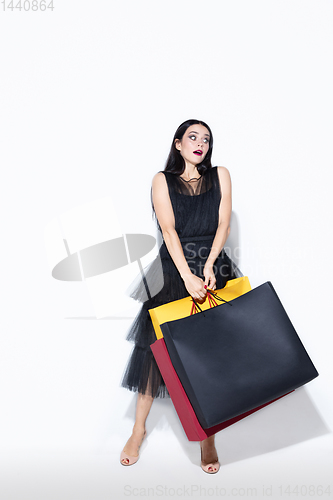 Image of Young woman in dress shopping on white background