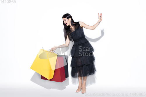 Image of Young woman in dress shopping on white background