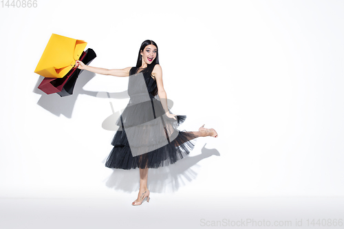 Image of Young woman in dress shopping on white background