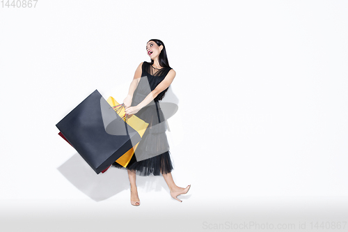 Image of Young woman in dress shopping on white background