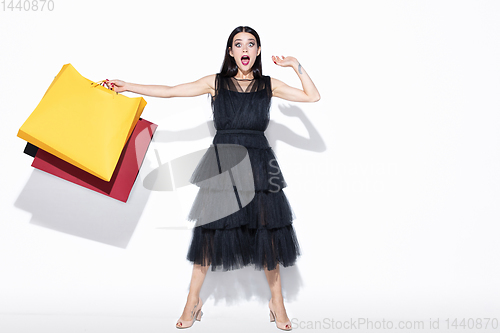 Image of Young woman in dress shopping on white background
