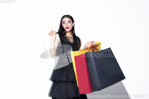 Image of Young woman in dress shopping on white background