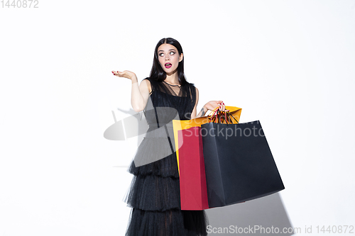 Image of Young woman in dress shopping on white background