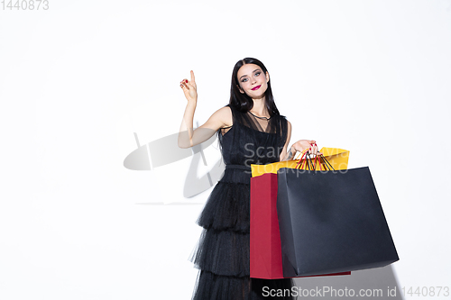 Image of Young woman in dress shopping on white background