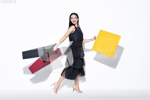 Image of Young woman in dress shopping on white background