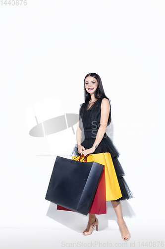 Image of Young woman in dress shopping on white background