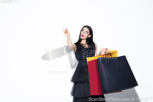 Image of Young woman in dress shopping on white background