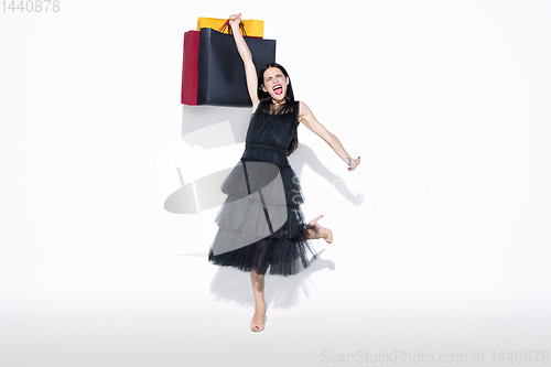 Image of Young woman in dress shopping on white background