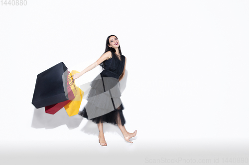 Image of Young woman in dress shopping on white background