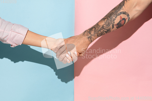 Image of Closeup shot of human holding hands isolated on yellow studio background.