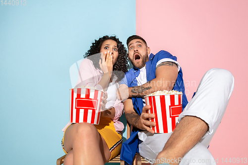 Image of Young emotional man and woman on pink and blue background