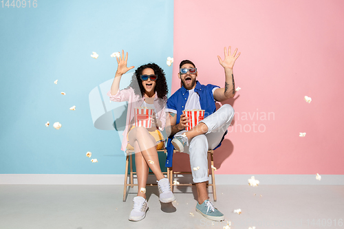 Image of Young emotional man and woman on pink and blue background