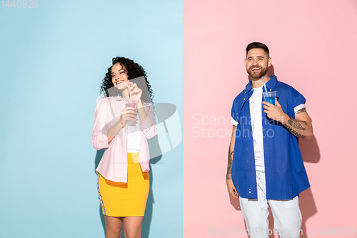 Image of Young emotional man and woman on pink and blue background