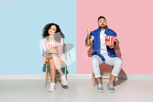 Image of Young emotional man and woman on pink and blue background