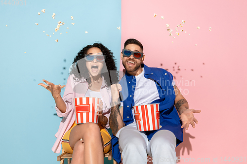 Image of Young emotional man and woman on pink and blue background