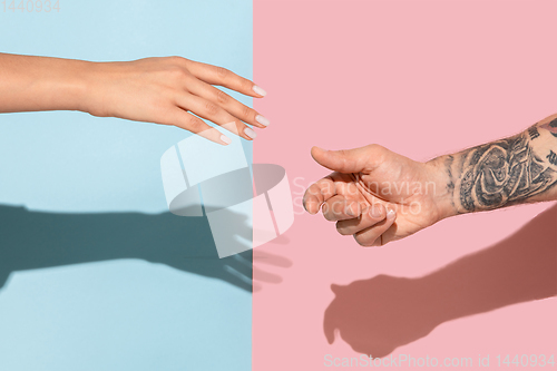 Image of Closeup shot of human holding hands isolated on yellow studio background.