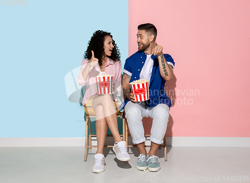 Image of Young emotional man and woman on pink and blue background