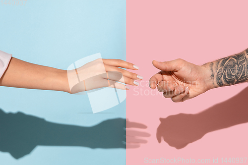 Image of Closeup shot of human holding hands isolated on yellow studio background.