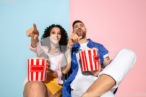 Image of Young emotional man and woman on pink and blue background