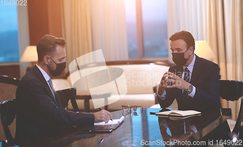 Image of business people wearing crona virus protection face mask on meeting