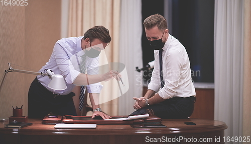 Image of business people wearing crona virus protection face mask on meeting