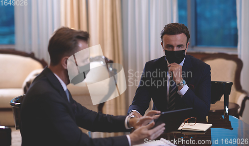 Image of business people wearing crona virus protection face mask on meeting