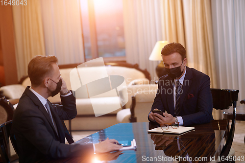 Image of business people wearing crona virus protection face mask on meeting