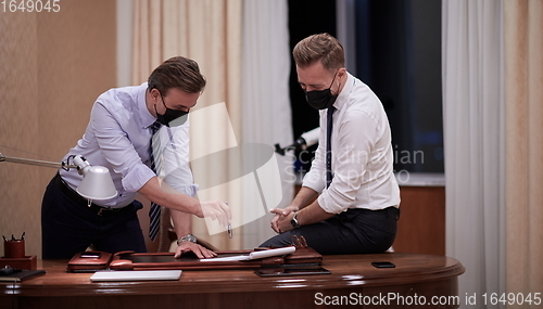 Image of business people wearing crona virus protection face mask on meeting