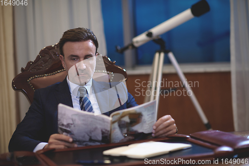 Image of corporate business man at office reading magazine