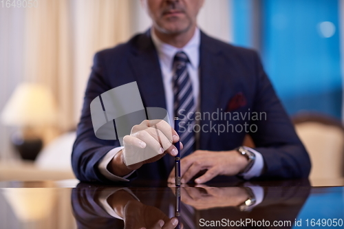 Image of corporate businessman at luxury office pen holding 