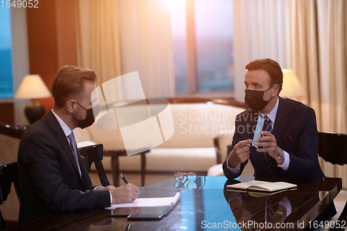 Image of business people wearing crona virus protection face mask on meeting