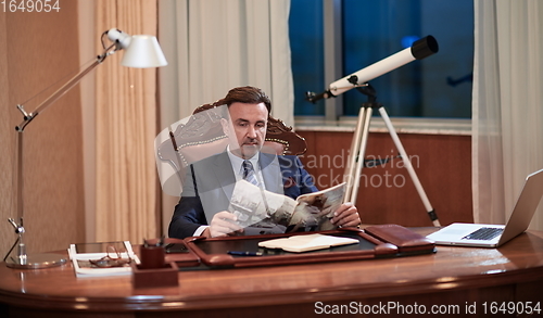 Image of corporate business man at office reading magazine