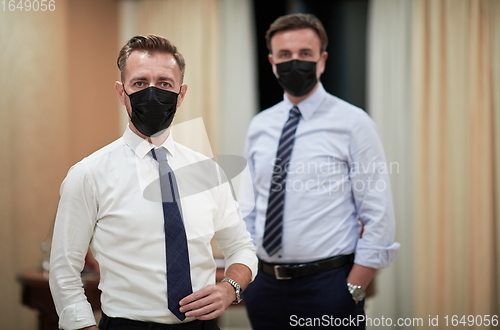 Image of business team wearing crona virus protection face mask