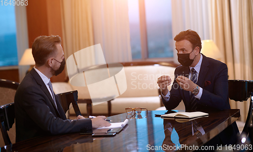 Image of business people wearing crona virus protection face mask on meeting