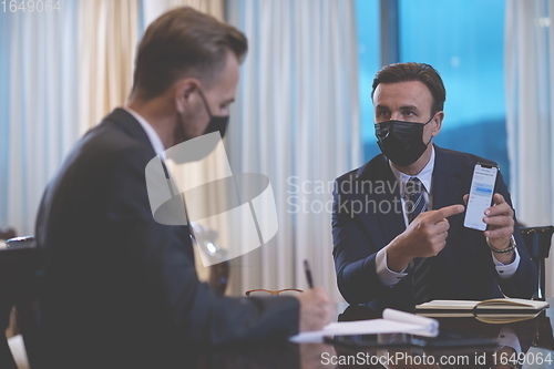 Image of business people wearing crona virus protection face mask on meeting