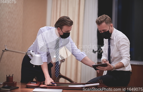 Image of business people wearing crona virus protection face mask on meeting