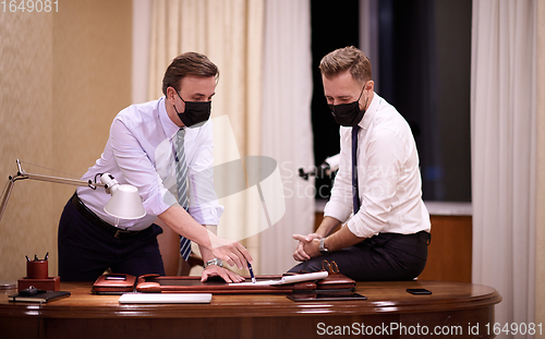 Image of business people wearing crona virus protection face mask on meeting