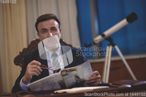 Image of corporate business man at office reading magazine