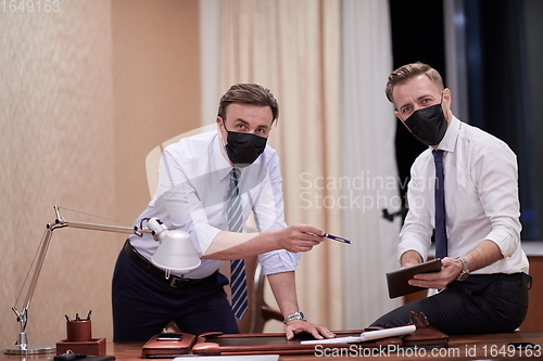 Image of business people wearing crona virus protection face mask on meeting