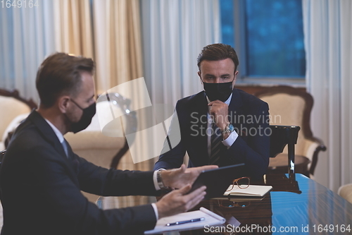 Image of business people wearing crona virus protection face mask on meeting