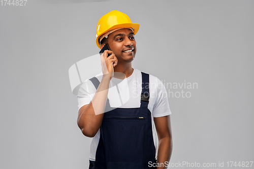 Image of indian builder in helmet calling on smartphone