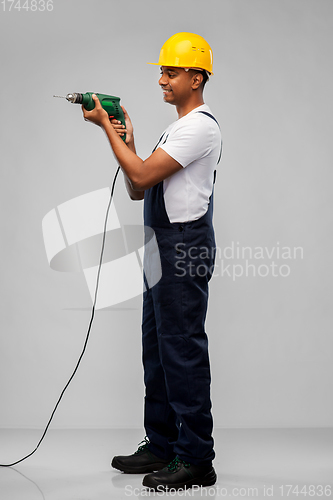 Image of happy indian builder in helmet with electric drill