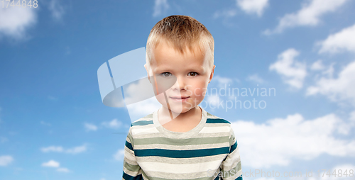 Image of little boy in striped shirt over blue sky